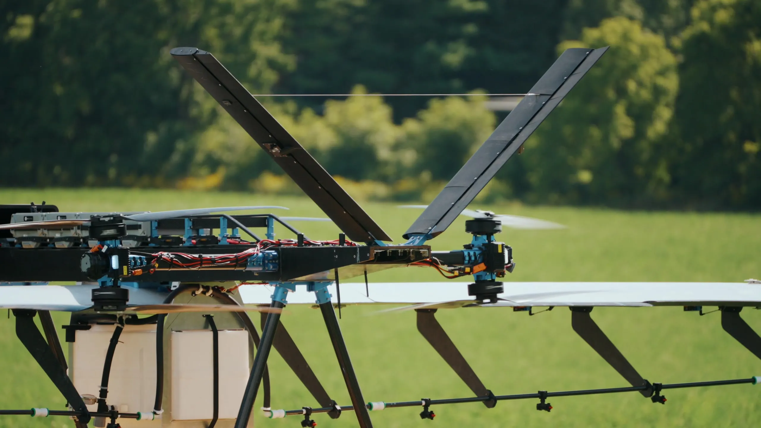 The U9 Spray seen from the side in a field, the spray boom running the length of the wing with nozzles spaced along it.